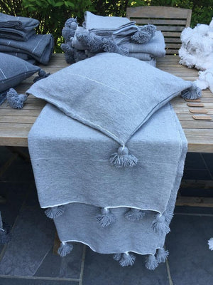 Housse de coussin à pompons gris clair