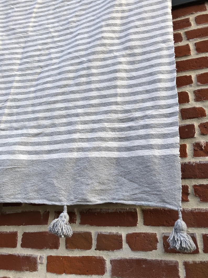 Plaid gris à rayures et pompons