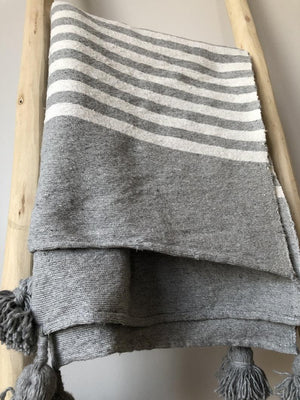 Plaid gris à rayures et pompons